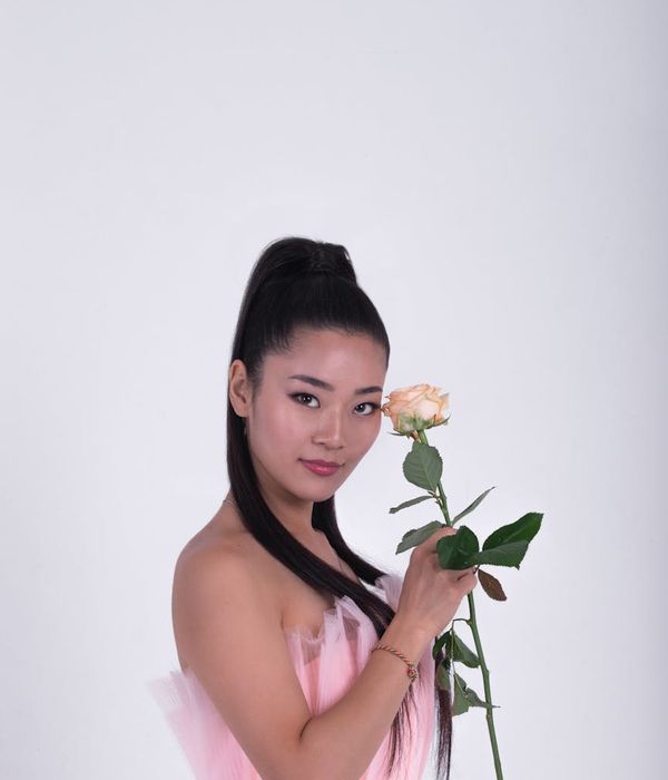 Woman in a graceful yoga pose with light accents on a dark background.